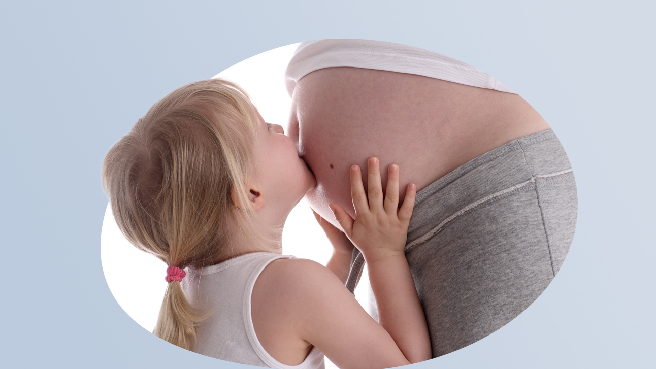 Gravidanza e nascita - 16/9 Una bambina bacia con affetto il pancione di una donna incinta.